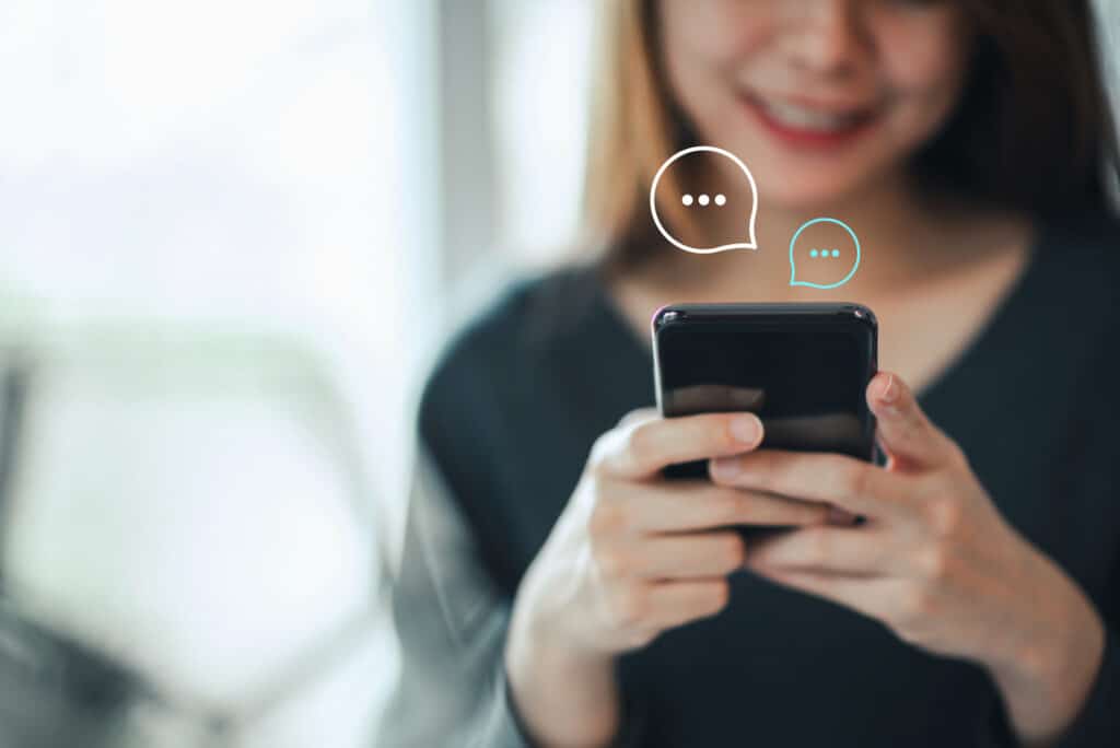Mujer joven recibiendo una notificación SMS para rastrear su paquete