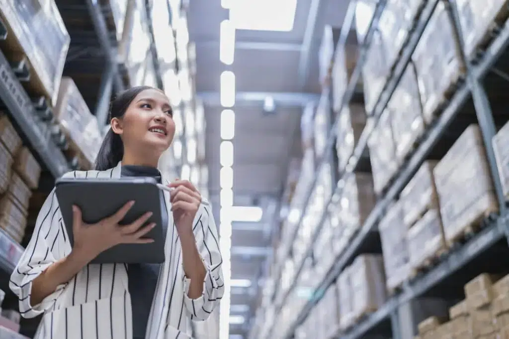 jeune femme dans son entrepôt vérifiant le stock chez son fournisseur dropshipping pour sa société de bijoux