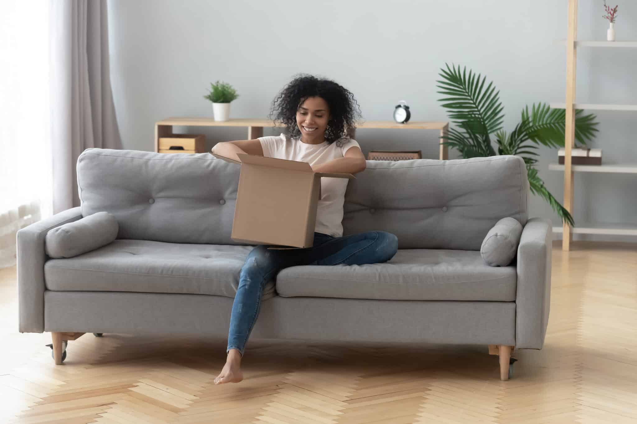 jeune femme ouvrant son colis contenant un article de décoration expédié en dropshipping