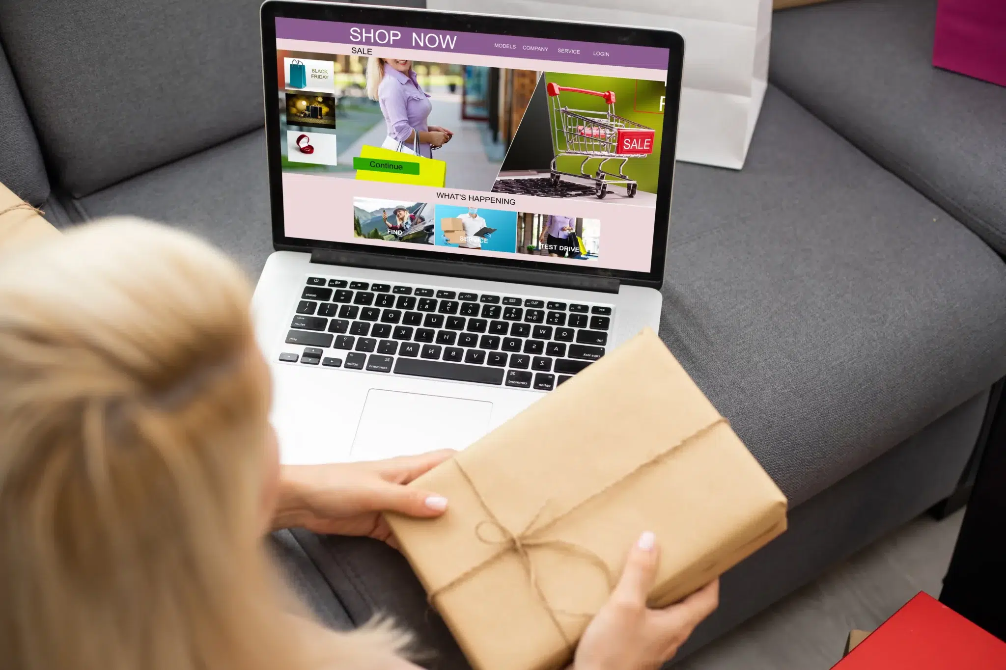 Femme devant site e-commerce tenant un colis dans les mains